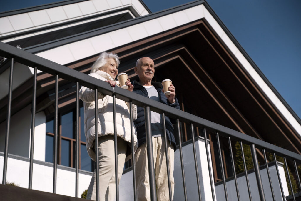 low-angle-smiley-senior-couple-with-coffee-cups